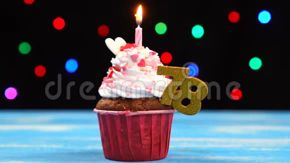 带有蜡烛的美味生日蛋糕和78号的彩色模糊灯光背景视频的预览图