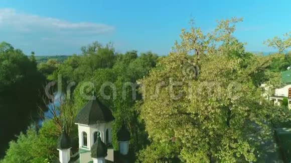 鸟瞰教堂之间的春天树木开花和宁静的湖泊4K视频的预览图