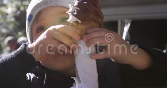 可爱的小男孩在蛋筒里舔冰淇淋视频的预览图