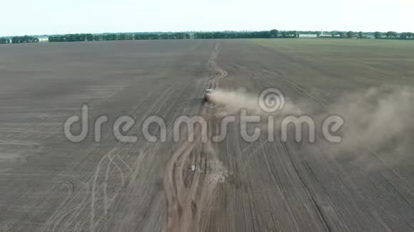 驾驶拖拉机穿越田野的无人机射击视频的预览图