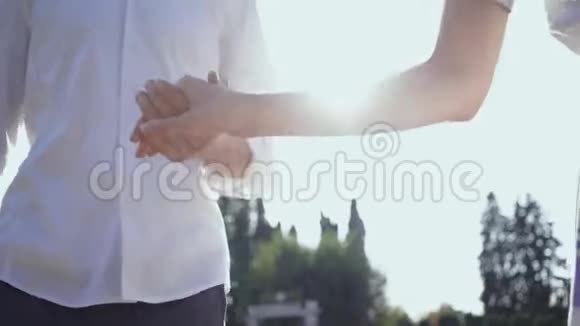 在公园或花园里散步的情侣牵手男人和女人一起在户外玩视频的预览图