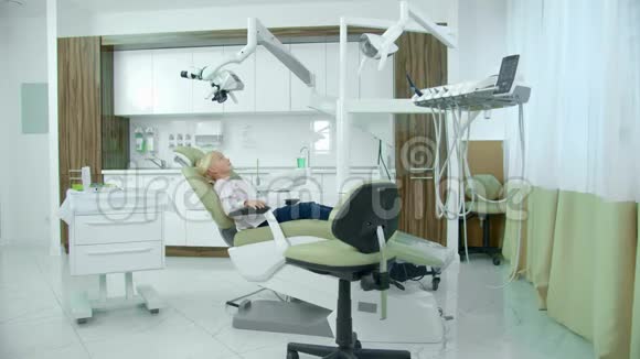 小女孩坐在牙医椅上视频的预览图