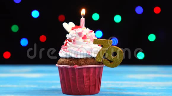 带有蜡烛的美味生日蛋糕和79号的彩色模糊灯光背景视频的预览图