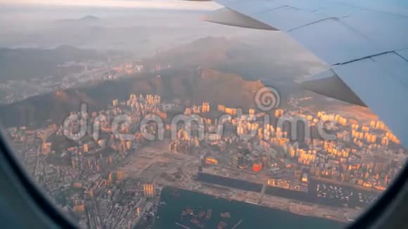 飞机飞行日落时分在香港上空飞行的飞机机翼从平面的窗口查看飞机视频的预览图
