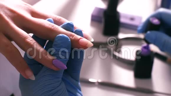 医生把紫罗兰色的紫胶涂在病人指甲上视频的预览图