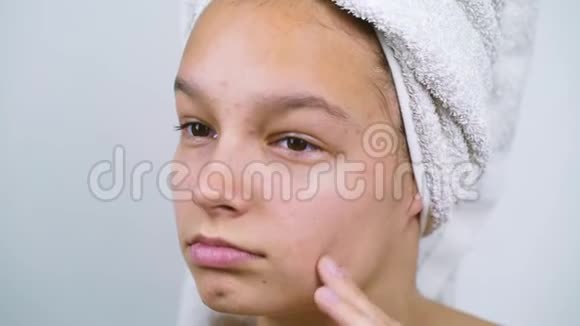穿着浴巾摸脸皮肤有问题的少女视频的预览图