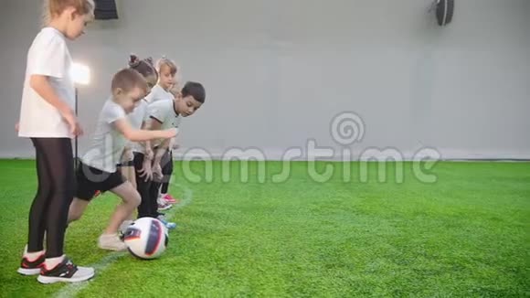 室内足球场孩子们开始玩一个男孩领球视频的预览图