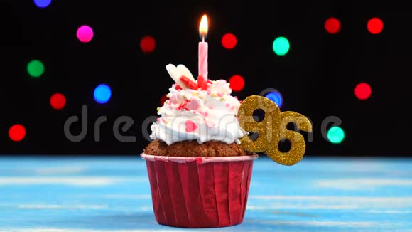 带有蜡烛的美味生日蛋糕和96号的彩色模糊灯光背景视频的预览图