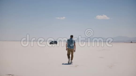 镜头接近年轻放松的游客走向小型货车欣赏阳光明媚的盐湖沙漠视频的预览图