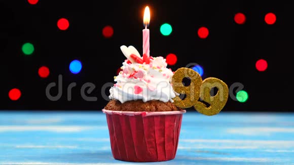 带有蜡烛的美味生日蛋糕和99号的彩色模糊灯光背景视频的预览图
