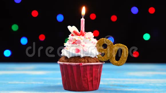 带有蜡烛的美味生日蛋糕和90号的彩色模糊灯光背景视频的预览图