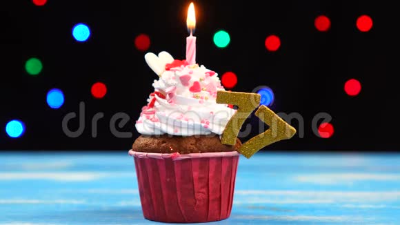 带有蜡烛的美味生日蛋糕和77号的彩色模糊灯光背景视频的预览图