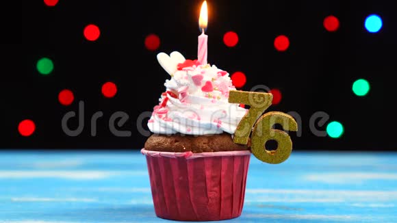 带有蜡烛的美味生日蛋糕和76号的彩色模糊灯光背景视频的预览图