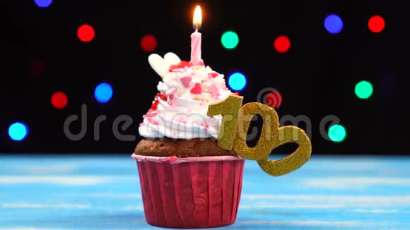带有蜡烛的美味生日蛋糕和彩色模糊灯光背景上的100个数字视频的预览图