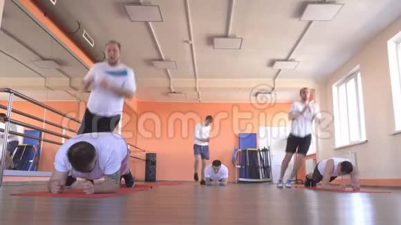 在一个现代化的健身中心一组双打的白种人男子进行跳跃运动以减肥和促进健康视频的预览图