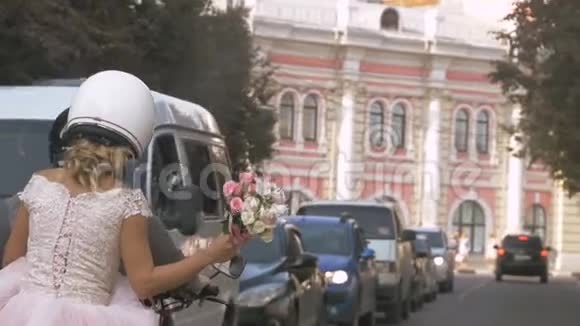 在夏天的城市里新婚夫妇骑着摩托车在城市里穿梭新娘正在举行婚礼视频的预览图