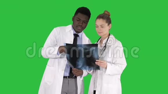 年轻的女医生和美国黑人医生看着绿色屏幕上肺部的x射线照片ChromaKey视频的预览图