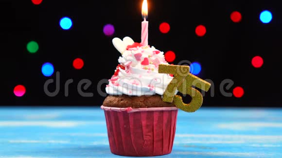 带有蜡烛的美味生日蛋糕和75号的彩色模糊灯光背景视频的预览图