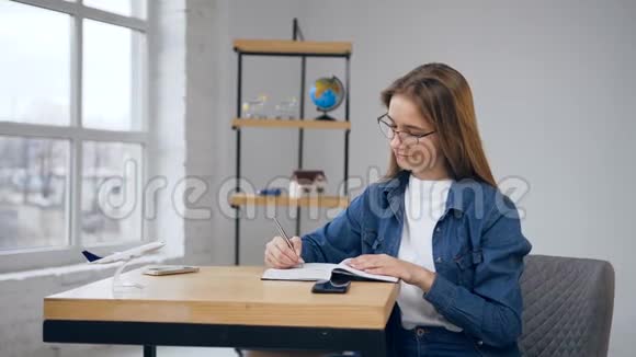 专注的白种人女人在家里的笔记本上写作视频的预览图