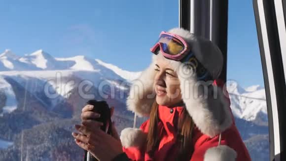 在一个封闭的滑雪电梯里的特写女孩上升到山顶视频的预览图