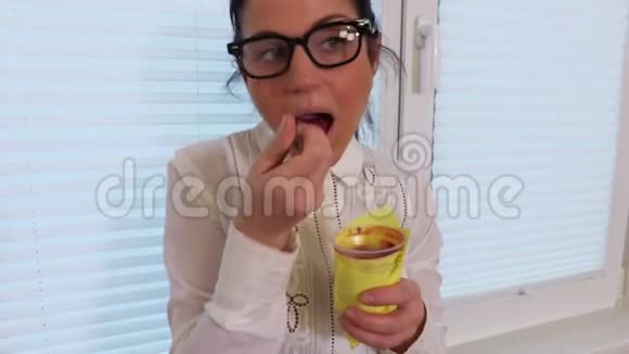 女性靠近窗户吃酸奶视频的预览图