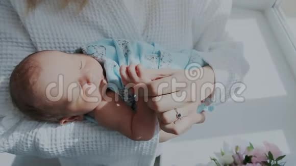 关上门一个可爱的小新生婴儿在妈妈怀里睡着了可爱的孩子在睡觉视频的预览图