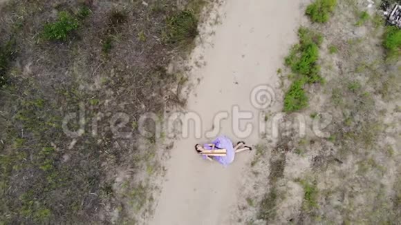 在沙漠里躺在沙滩上弹奏竖琴的女竖琴师的无人机射击视频的预览图