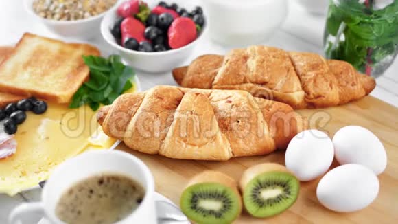 在木板上用美味的早餐食物围合两个新鲜的大牛角面包视频的预览图