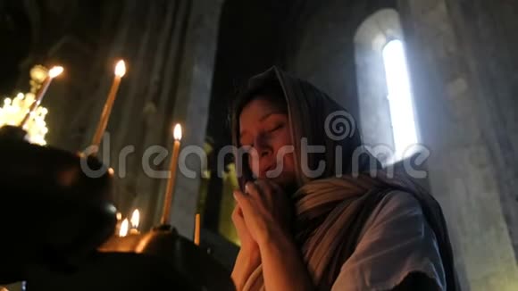 戴头巾的女人在东正教的偶像面前祈祷视频的预览图