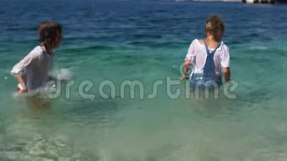 克罗地亚的假日孩子们在一个小镇和一个码头的背景下在清澈的海水中飞溅美丽美丽视频的预览图