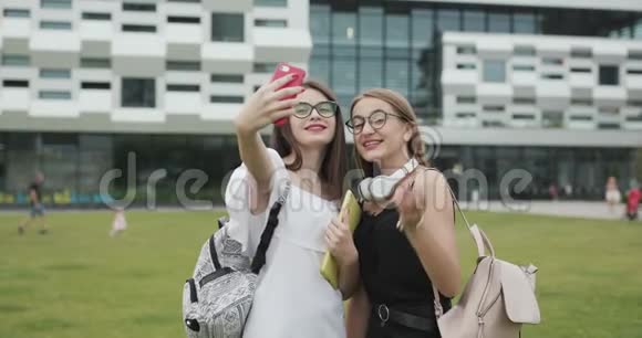 女性博主在现代城市背景下拍摄自拍视频户外肖像漂亮快乐的女孩制作视频视频的预览图