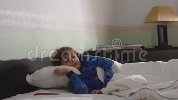 可爱的小男孩早上醒来时头发凌乱穿着睡衣的肖像孩子醒来却不想视频的预览图