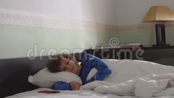 可爱的小男孩早上醒来头发凌乱穿着睡衣孩子睡醒了然后离开视频的预览图