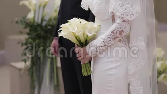 新郎和新娘在婚礼中的中间位置站在拱门外视频的预览图