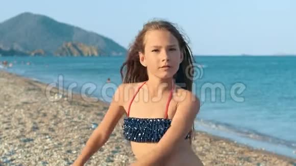 年轻女孩在海边跳舞快乐快乐的孩子在海滩上玩得开心视频的预览图