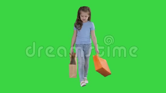 带着购物袋走在绿色屏幕上的小女孩Chroma键视频的预览图