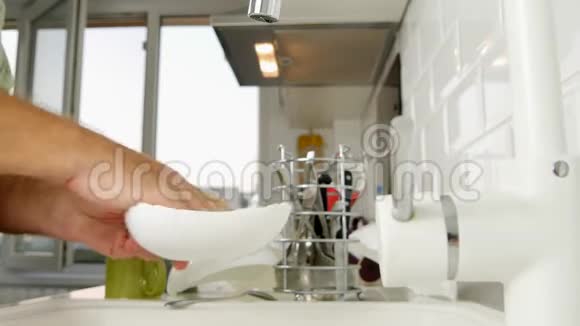 在厨房洗盘子的人在家工作视频的预览图