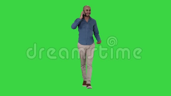 年轻的阿拉伯男人在电话里走来走去在绿色的屏幕上微笑铬钥匙视频的预览图