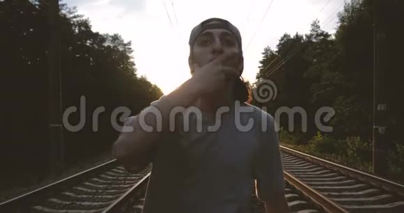 4k日落时分一个黑发男孩在铁路跑道上跳着舞视频的预览图