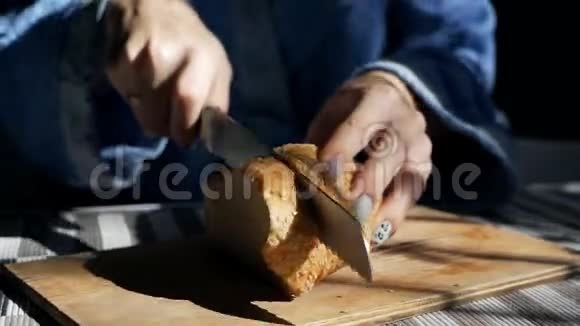 用一把面包刀把自制的粮食和谷物面包片放在木板上视频的预览图