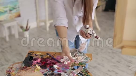 女孩拿起调色板上的颜料艺术学院视频的预览图