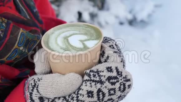 这段视频讲述的是在雪地冬季晨间户外举行热咖啡或茶蒸杯的针织手套中的贴身手视频的预览图