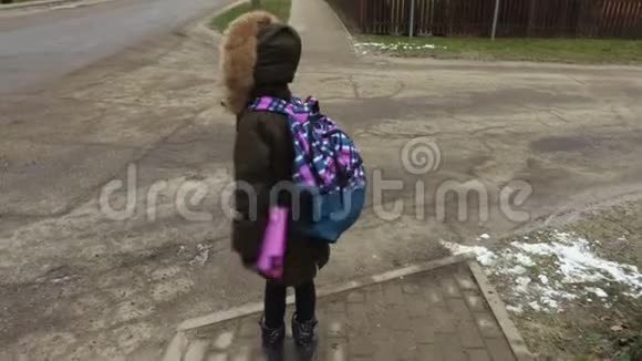 放学后带背包的小女孩试着过马路视频的预览图