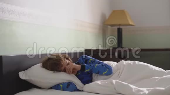 一个可爱的小男孩头发凌乱早上醒来站着离开卧室视频的预览图