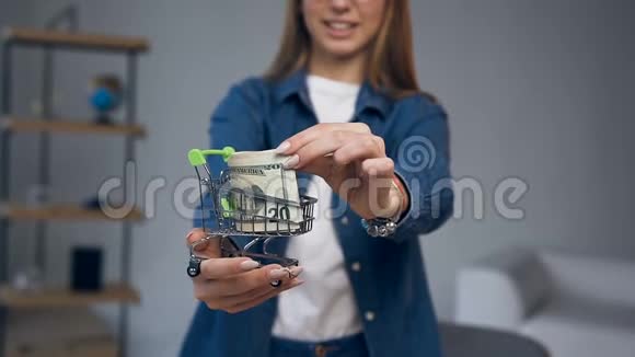 近距离拍摄的年轻女子手拿着购物车的钱视频的预览图
