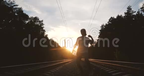 4k那个男孩在火车轨道附近顶着太阳跳舞动作很慢视频的预览图