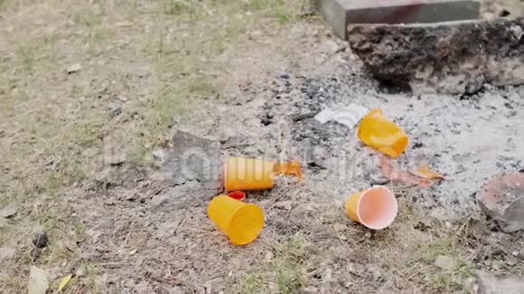 粗鲁的男人扔下橙色的塑料杯塑料污染视频的预览图