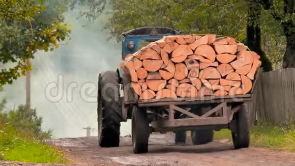 拖拉机在熏制的地面道路上驾驶着掉落的松苹果建筑材料运输地下村庄道路视频的预览图