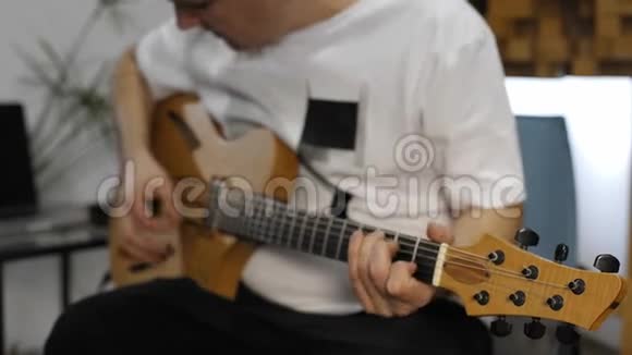 音乐家在家庭音乐工作室里弹电吉他时手腕疼痛视频的预览图