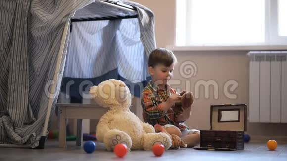 一个小孩在他的房间里盖了假发在那里和一只玩具熊玩耍视频的预览图